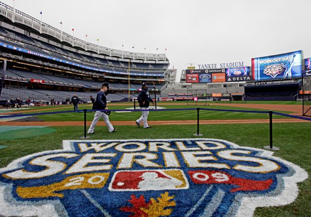 Eric Hinske and CC Sabathia walk the newly painted World Series logo on the field at Yankee Stadium. 
